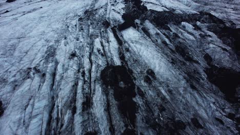 Drone-Volando-Sobre-El-Glaciar-Solheimajokull-Con-La-Cámara-Inclinándose-Lentamente,-Islandia-4k