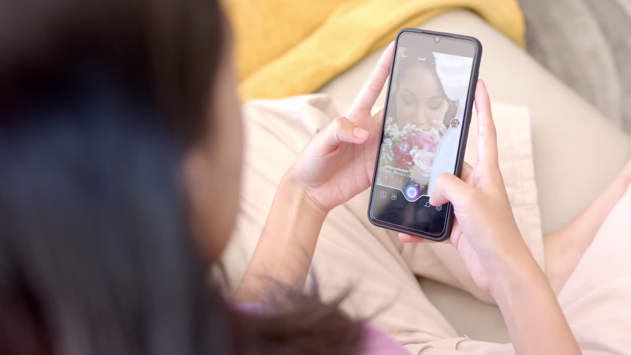 Taking photo of cake, teenager using smartphone while relaxing indoors