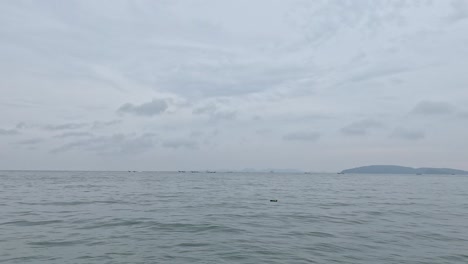 평화로운 바다 풍경과 구름이 가득한 하늘 아래의 먼 섬