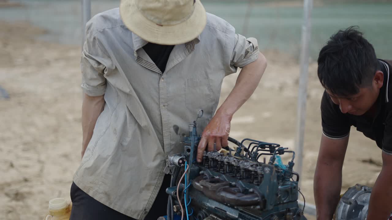 Two Workers Repairing a Diesel Engine
