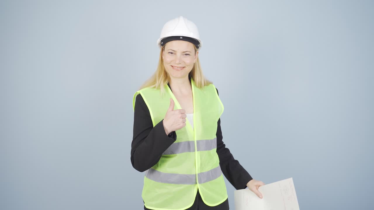 엔지니어는 카메라를 쳐다보고 긍정적인 제스처를 합니다.