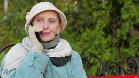 elderly woman talking on mobile phone in a park