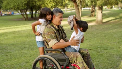 disabled military dad playing with kids in park