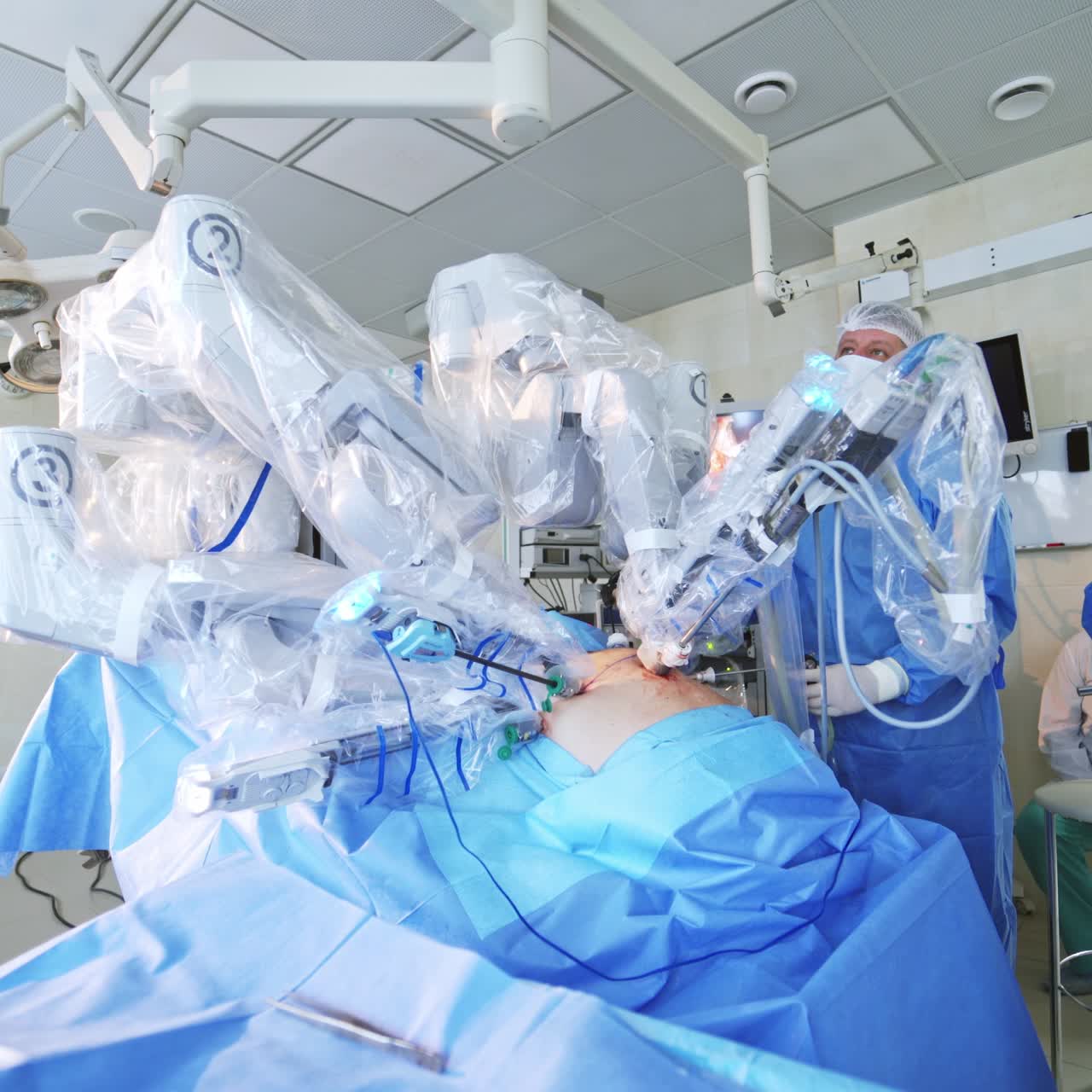 Doctors using surgical robot in hospital. Minimally invasive surgery with robotic technology equipment. Team of doctors and futuristic machine in operating room.