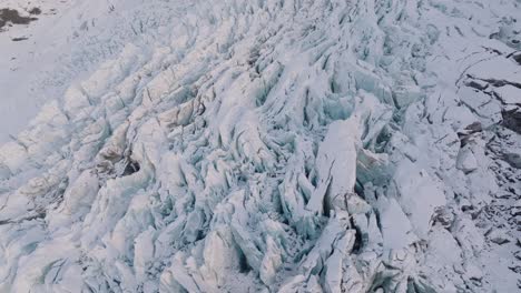Luftaufnahme-über-Strukturierte-Eisformationen-Im-Schneebedeckten-Falljökull-Gletscher,-Island,-Bei-Sonnenuntergang