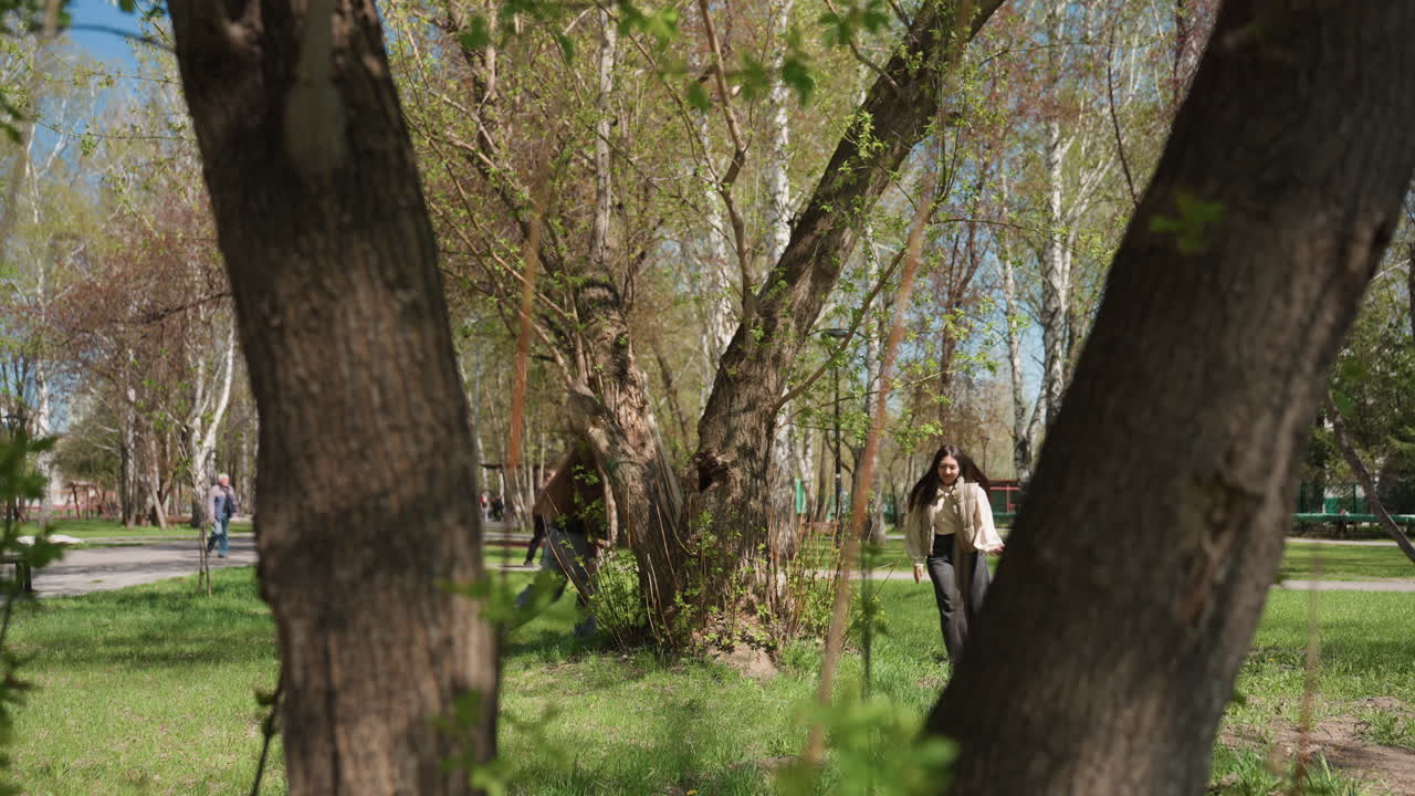 도시 공원 나무에 기대어 가방을 어깨에 메고 싹이 트는 가지 아래에서 조용히 휴식을 취하는 백인 통근자; 사색적인 분위기, 캐주얼 재킷, 부드러운 햇살, 보행자 도로