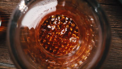 whisky decanter, cigar smoldering in ashtray and ice cubes dropped into glass in slow motion