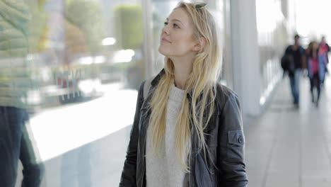 beautiful woman looking at shop window