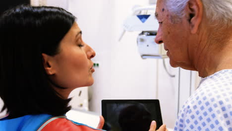 doctora discutiendo con el paciente a través de una tableta digital