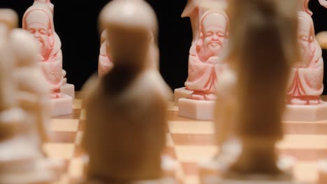 Chess-ivory-figures-revealing,-Tracking-tilt-up,-Extreme-close-up