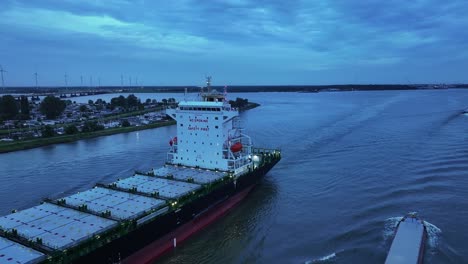 as light fades over the river dortsche kil a large container ship sails onwards, aerial