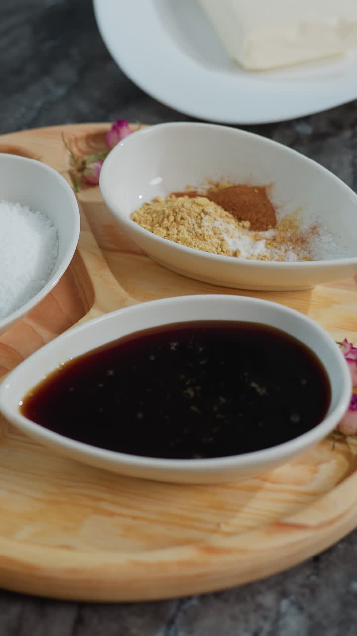 , 향신료, 설탕, 롤링 핀이 있는 나무 트레이를 특징으로 한 검은색 우아한 타일에서 아침 식사 설정의 회전 시각, 배경에 보이는 부드러운 조명과 함께 우아한 구성