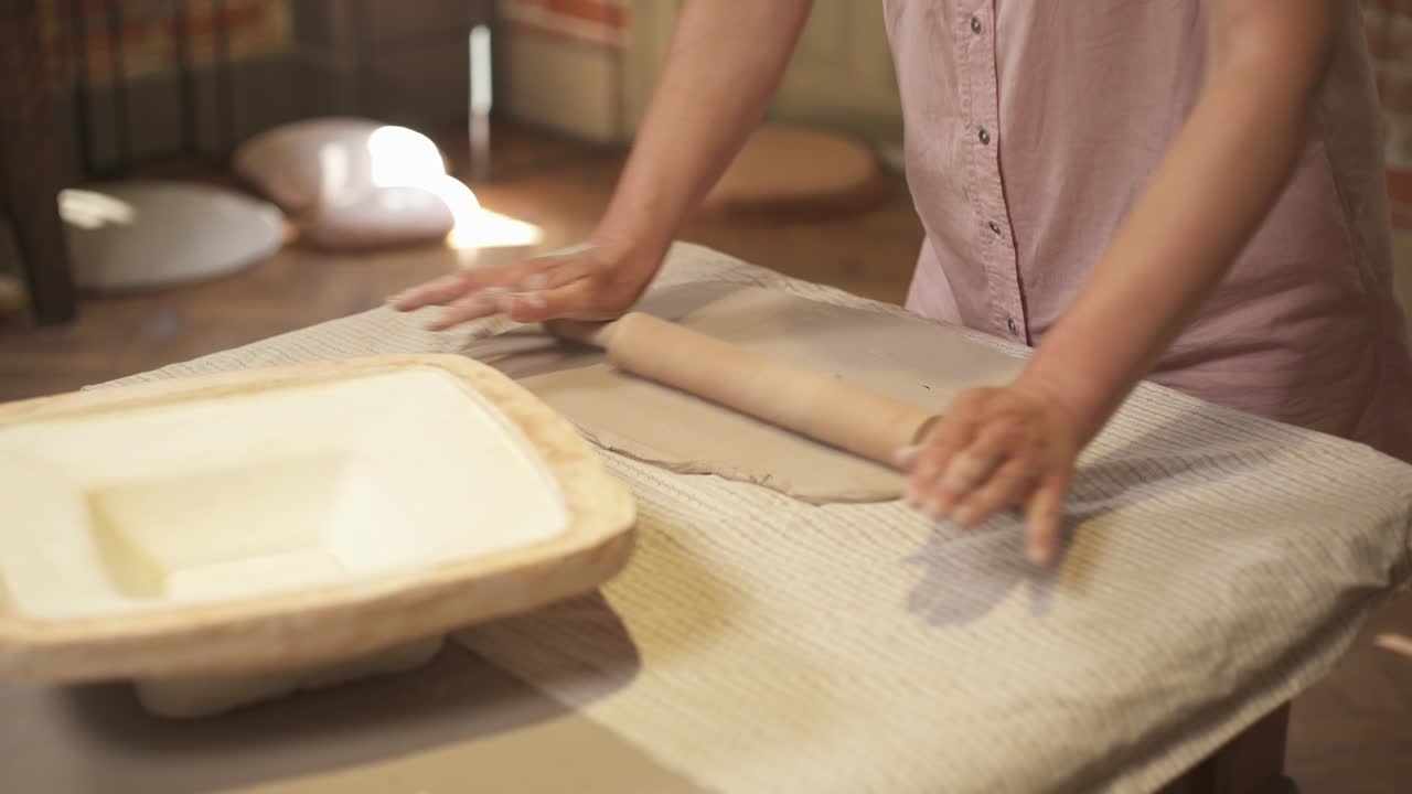 A close-up of female potter kneading clay before molding. Artist in the workshop. Work and hobby concept