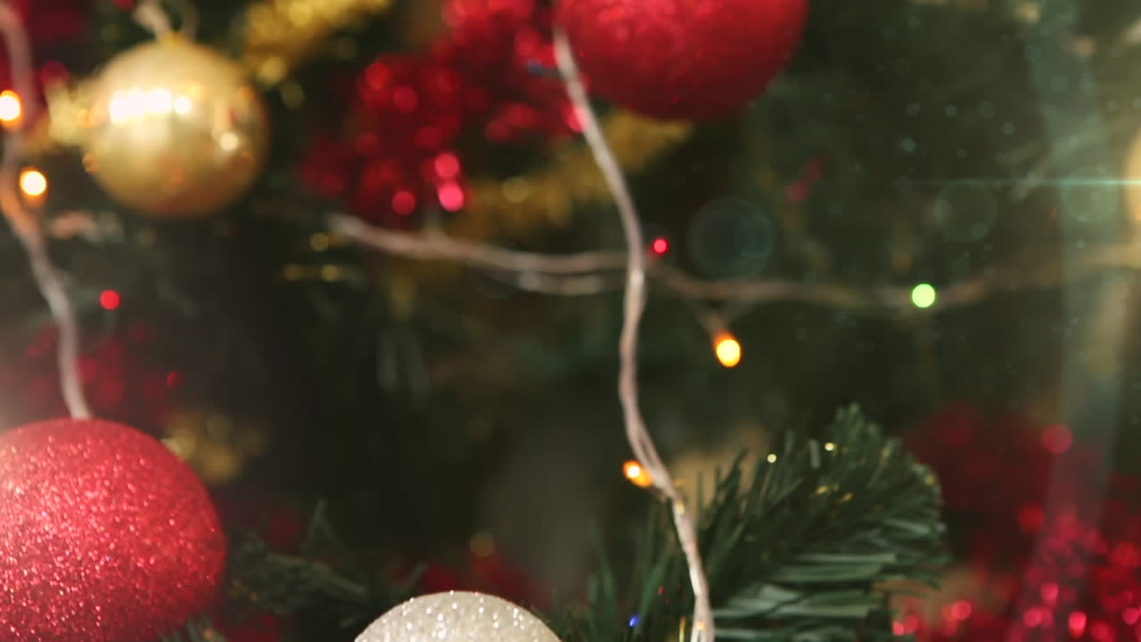las luces brillantes y las bolas en un árbol celebran la tradición navideña.