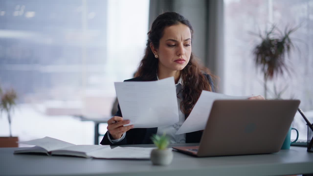 Frowning woman examining documentation finding mistake at workplace closeup
