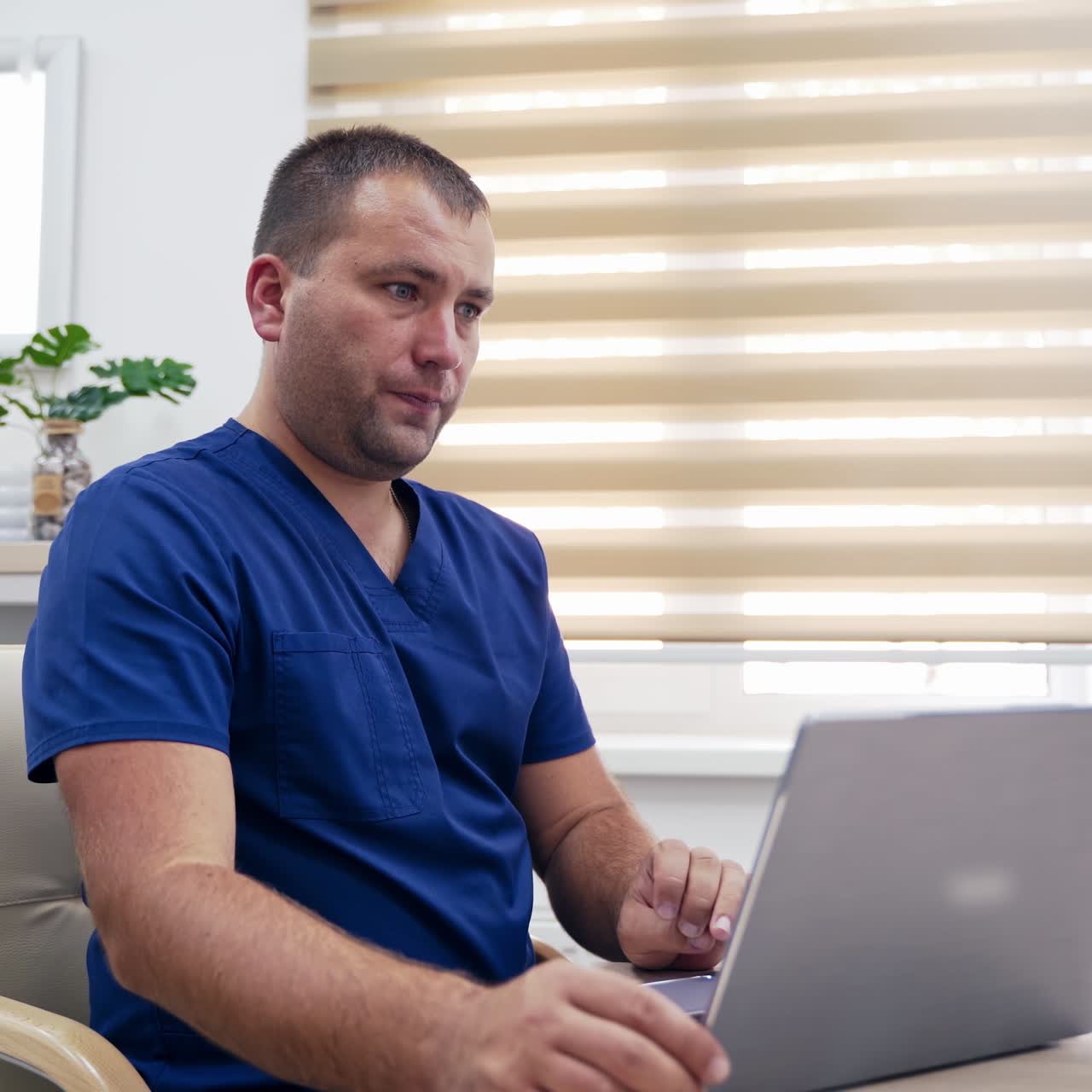 Doctor making video call on laptop. Professional male physician speaking to patient while looking at pc screen communicating in web chat. Telemedicine concept.