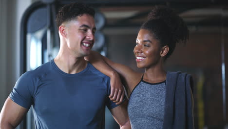 two fit young people standing together in the gym