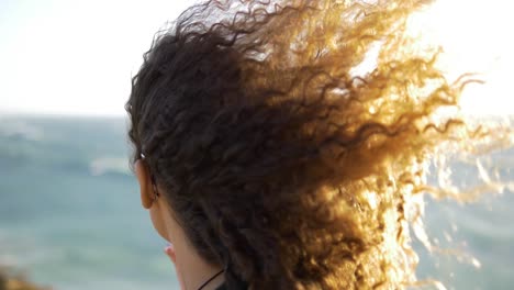 Zeitlupe-Eines-Mädchens,-Das-Den-Strand-Mit-Haaren-Betrachtet,-Die-Mit-Dem-Wind-Fliegen