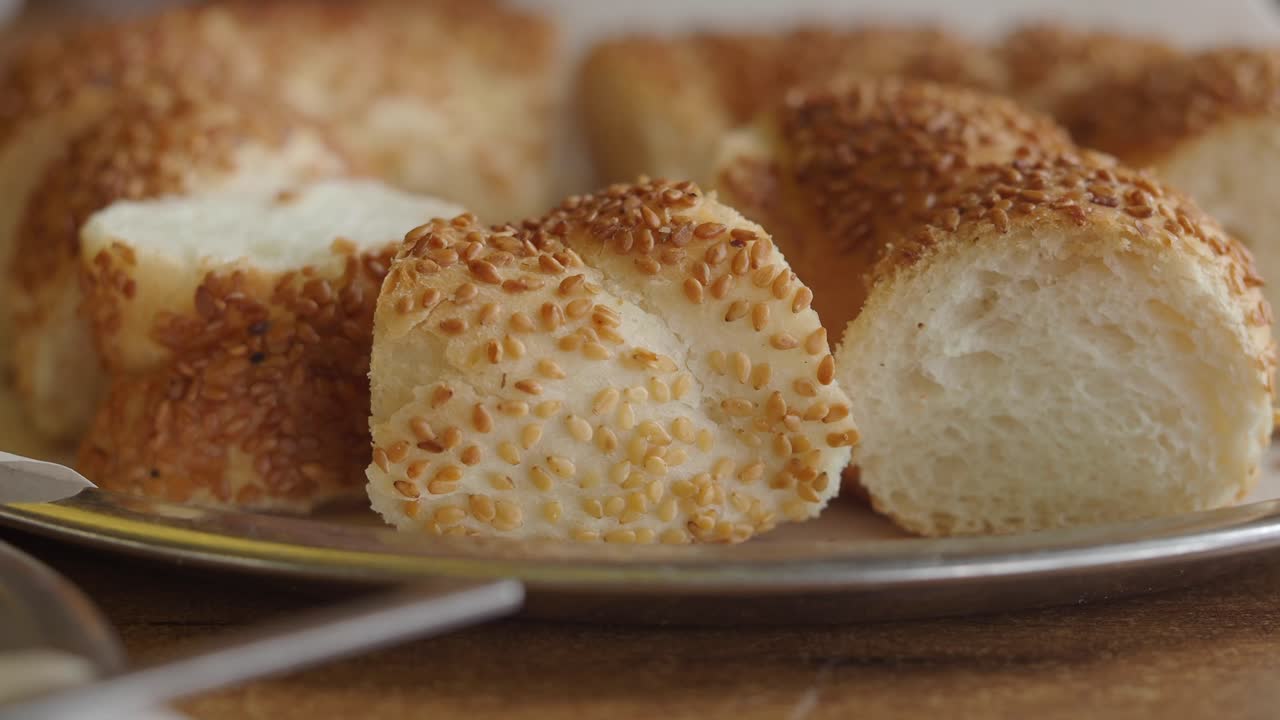 Close-up of Hand Picking Up Sesame Seed Bread from a Tray
