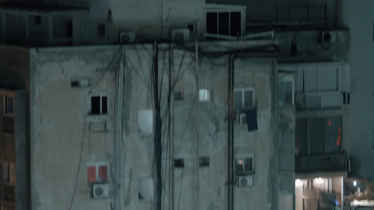 casa de varios pisos desgastada con fiesta nocturna en el techo