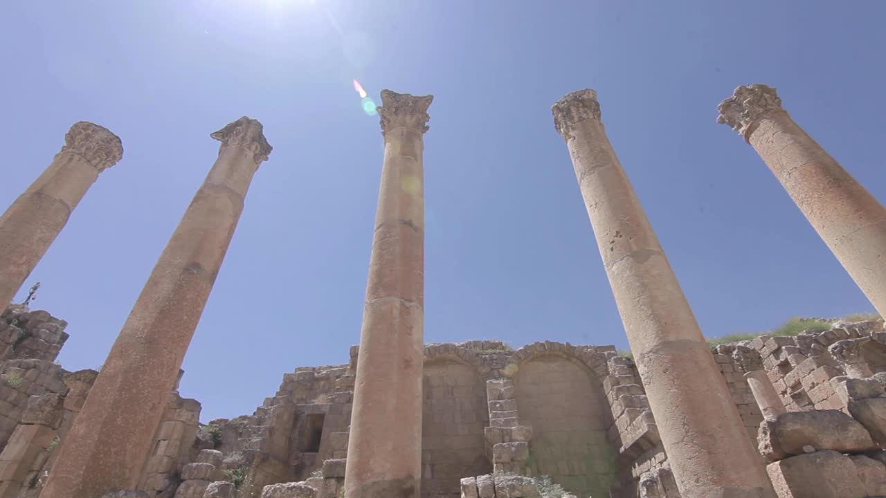 Time-Lapse ancient pillars, sun flare, clear sky, Jordan, low angle, traveling shot