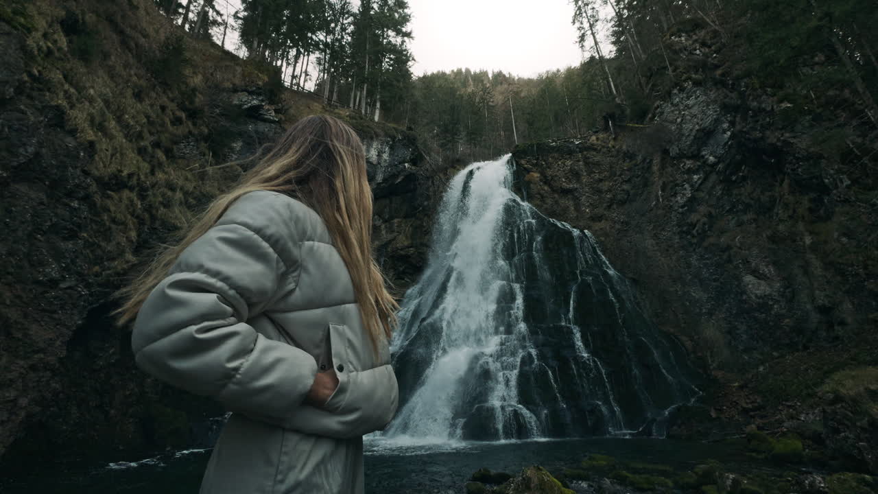 Woman Standing at Waterfall in Forest