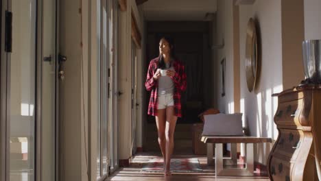 Mixed-race-woman-walking-by-a-window-at-home