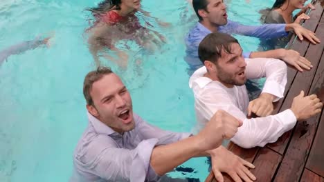 amigos felices jugando en la piscina