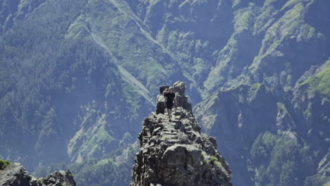 el escalador camina por la formación rocosa en las montañas con una fuerte caída a cada lado