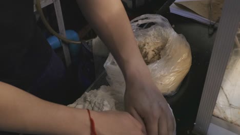 vendedor de comida callejera preparando la masa dándole forma de bolas