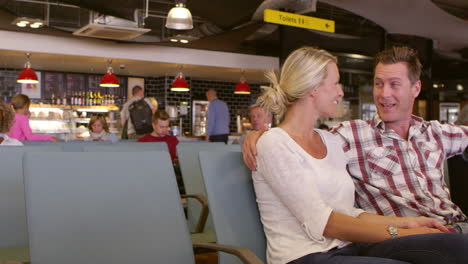 pareja esperando en la sala de salida del aeropuerto filmada en r3d