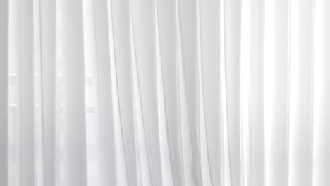 A-set-of-white-curtains-slightly-and-gently-moved-from-one-side-to-the-another