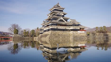 matsumoto castle on winter day, castle reflecting on moat, establishing shot