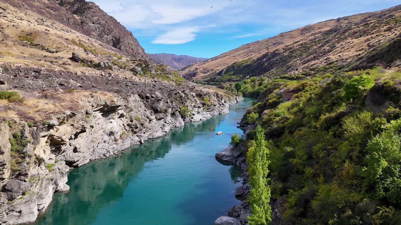 A 4K drone captures the Kawarau River near Queenstown, New Zealand. Drone highlights the clear river waters, surrounding mountains, and lush alpine landscape from above