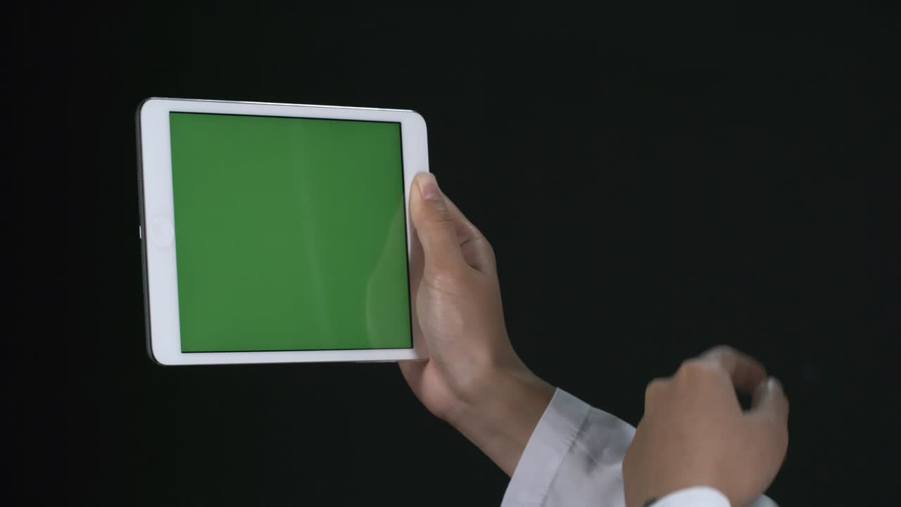 irreconocible trabajando en una tableta con pantalla verde