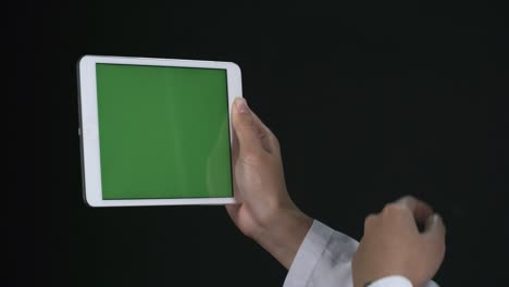 irreconocible trabajando en una tableta con pantalla verde