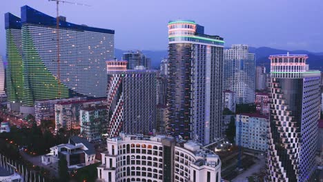 drone view of illuminated apartment skyscrapers at evening dawn