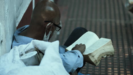older man reading a book outdoors