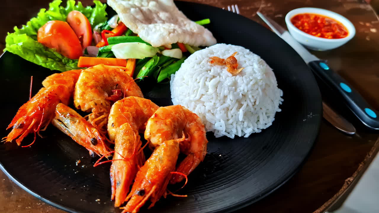 Asian fusion dish grill shrimp skewers rice mixed leaf salad prawn crackers plate