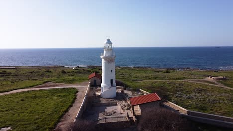 drone shot flying towards a beautiful lighthouse on the coast on cyprus, greece