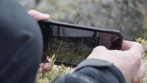 person taking picture of nature scene