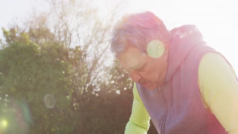 video of senior biracial man in sports clothes drinking water in sunny street