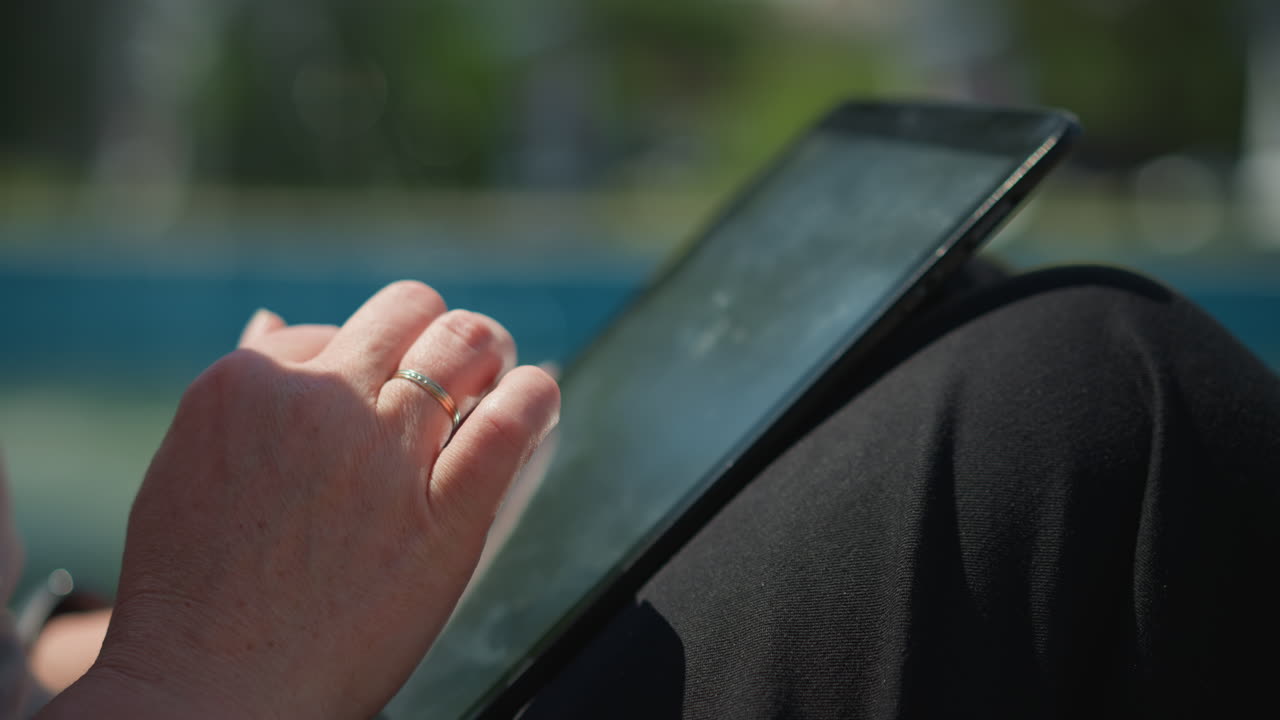 Close up of hand sliding through phone screen outdoors under warm sunlight, showing soft focus reflections and gentle touch, calm atmosphere symbolizing connection