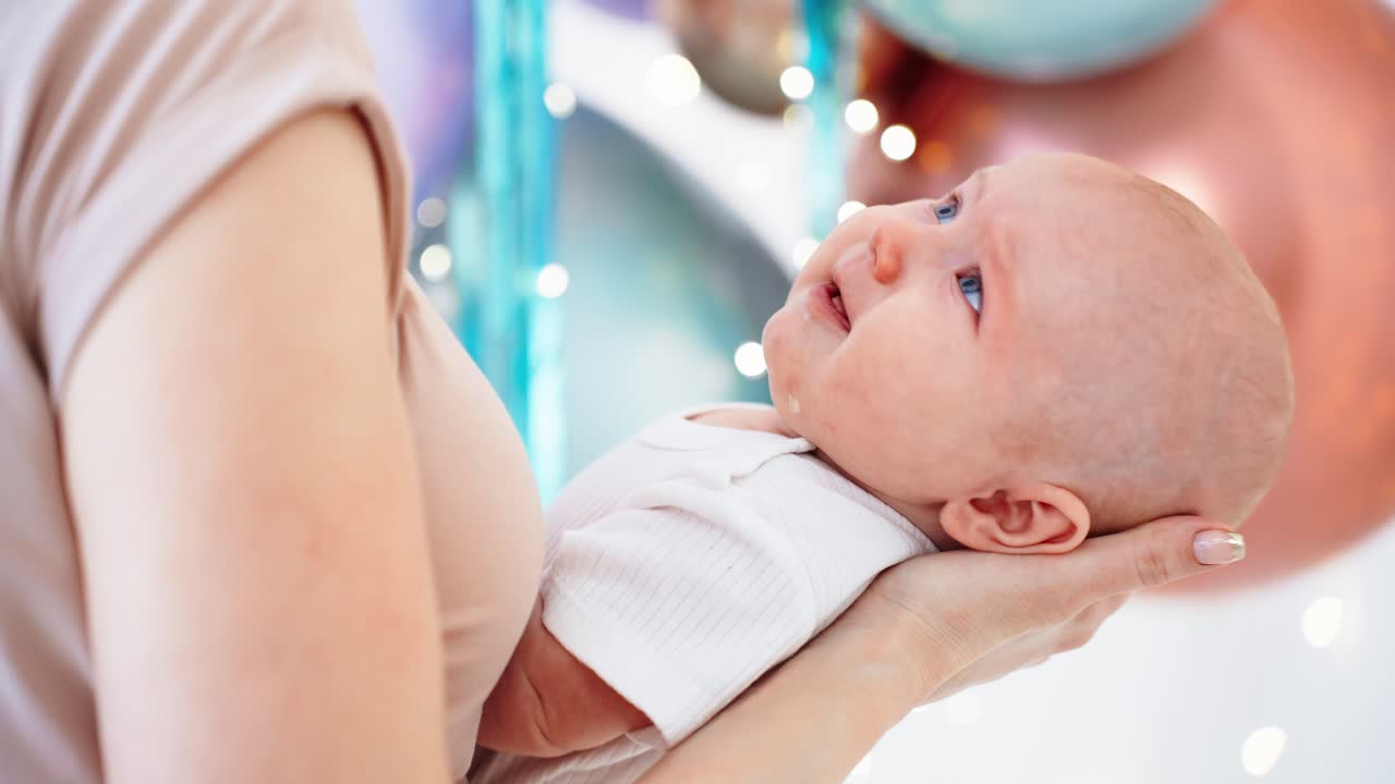 Mamma tiene dolcemente in braccio il suo adorabile neonato tra le decorazioni festive