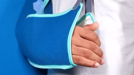 person with a broken arm in a blue sling