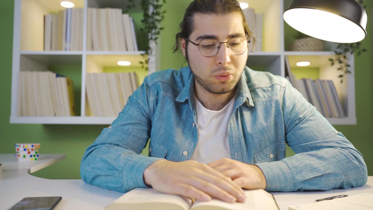 el estudiante masculino, que estudia hasta tarde, se queda dormido.