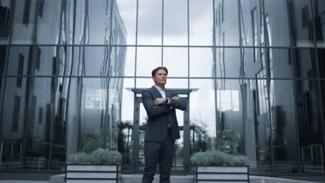 Serious-businessman-standing-outdoors-inspect-downtown-district.-Success-concept