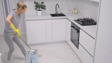 beautiful attractive cheerful girl mopping ceramic floor having fun dancing
