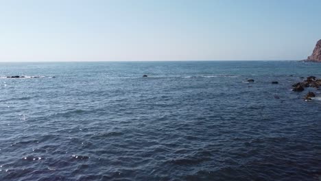 Flying Out of Tunnel Revealing Ocean off Coast of São Martinho do Porto, Portugal With Fishing Pole Resting on Rocks