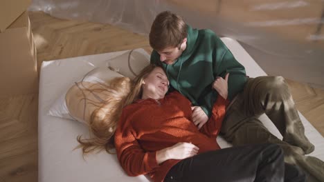 couple relaxing on mattress during a move